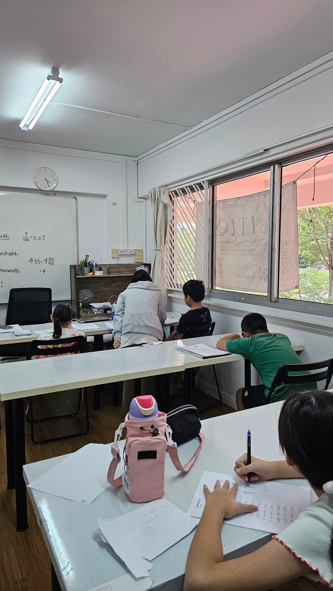 Ancourage Academy Primary Maths tutor teaching decimals to a small group at the whiteboard