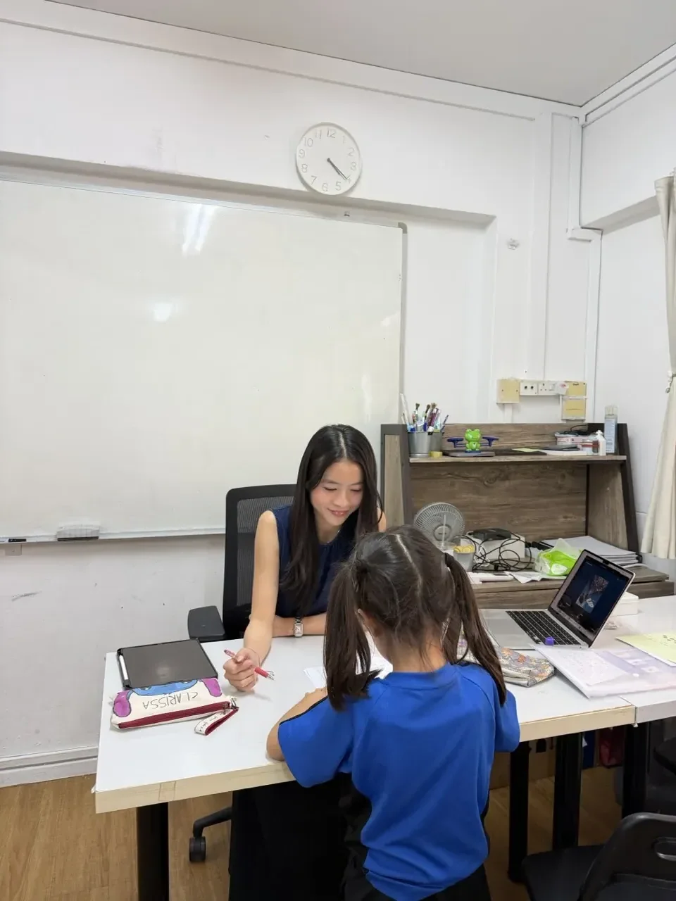 Tutor guiding a young IB Primary Years Programme (PYP) student during small-group tuition at Ancourage Academy, Bishan and Woodlands